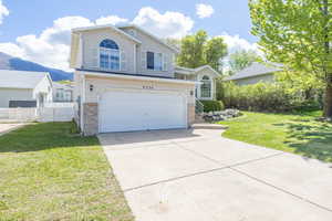 Traditional-style home featuring concrete driveway, an attached garage, brick siding, and a mountain view