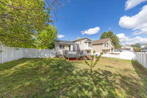 Rear view of house featuring a deck and a fenced backyard
