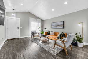 Living area featuring dark wood-style floors and suspended lighting