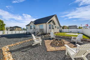Rear view of house with a patio area, an outdoor fire pit, a fenced backyard, and roof with shingles