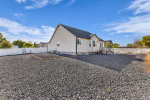 Back of house with a fenced backyard and a deck