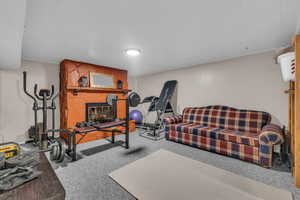 Exercise area with carpet flooring and a fireplace