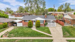 Bungalow-style home featuring a residential view, a chimney, concrete driveway, and brick siding