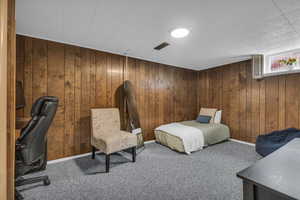 Carpeted bedroom with wood walls