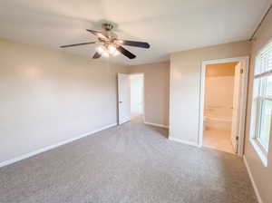 Unfurnished bedroom featuring light colored carpet, ceiling fan, and ensuite bathroom