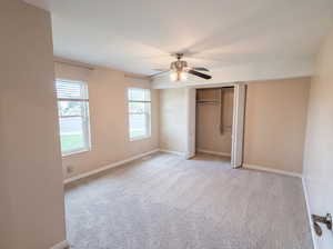 Unfurnished bedroom with a closet, light carpet, and a ceiling fan