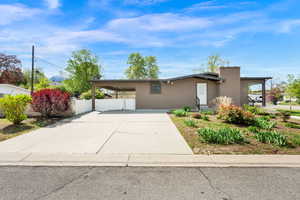 Exterior home featuring stucco siding, a carport, and driveway