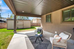 View of patio with a storage shed
