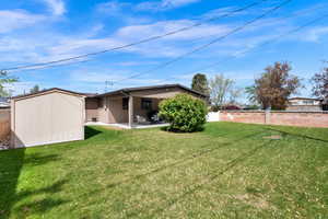 Back of house with a patio, a fenced backyard, a shed, and stucco siding