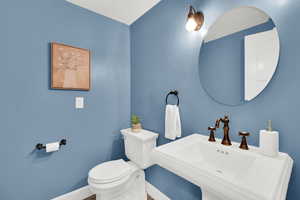 Half bathroom featuring toilet and baseboards