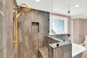 Full bath featuring walk in shower and a soaking tub