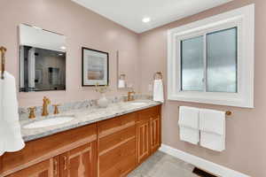 Full bath featuring double vanity and light tile patterned floors