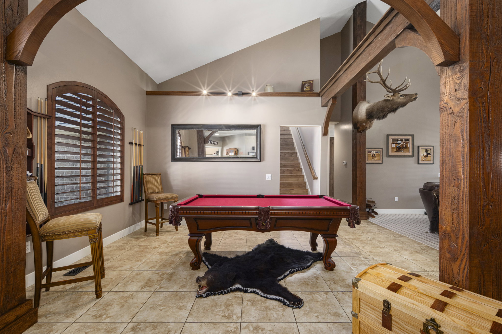 Rec room featuring arched walkways, vaulted ceiling, light tile patterned floors, and billiards