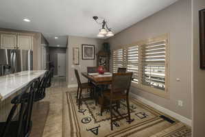 Dining room with a chandelier and light tile patterned floors
