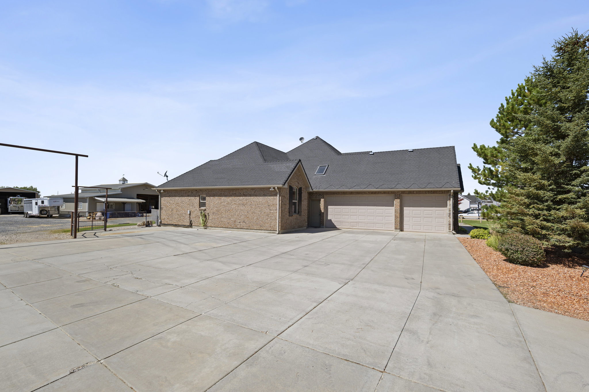 View of front of house with brick siding, driveway, an attached garage, and roof with shingles