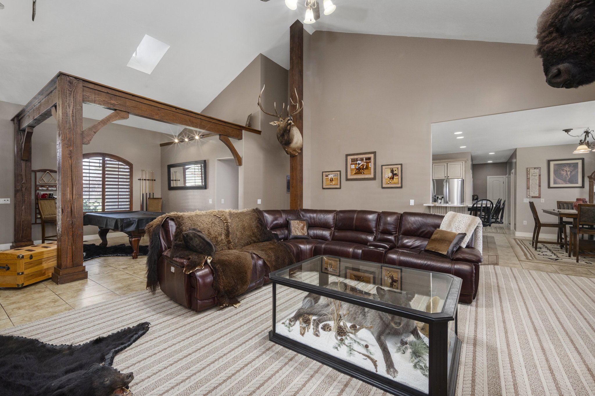 Living area featuring ceiling fan, lofted ceiling, light tile patterned floors, and billiards table