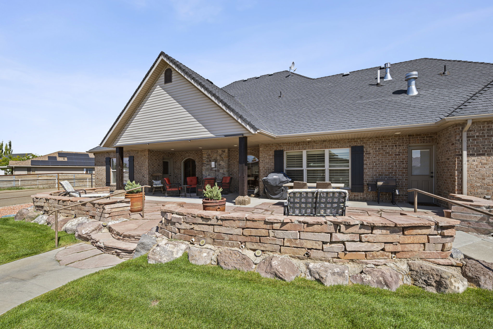 Back of house with a patio, a shingled roof, and brick siding