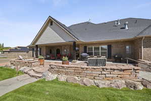 Back of house with a patio, a shingled roof, and brick siding
