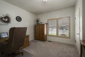 Home office with carpet floors and baseboards