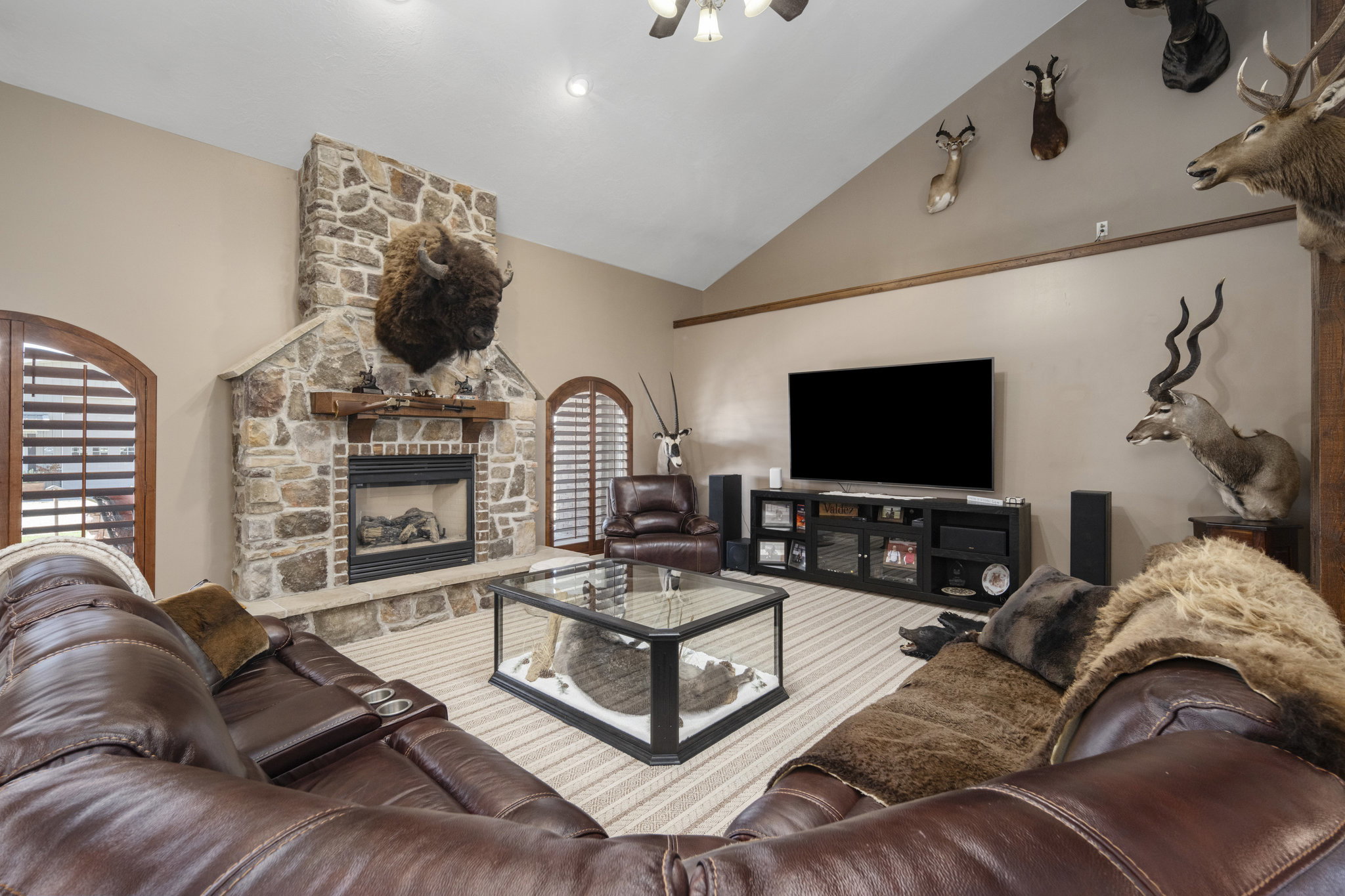Living area featuring a stone fireplace and lofted ceiling
