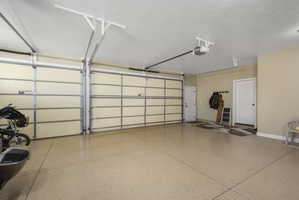 Garage featuring baseboards and a garage door opener