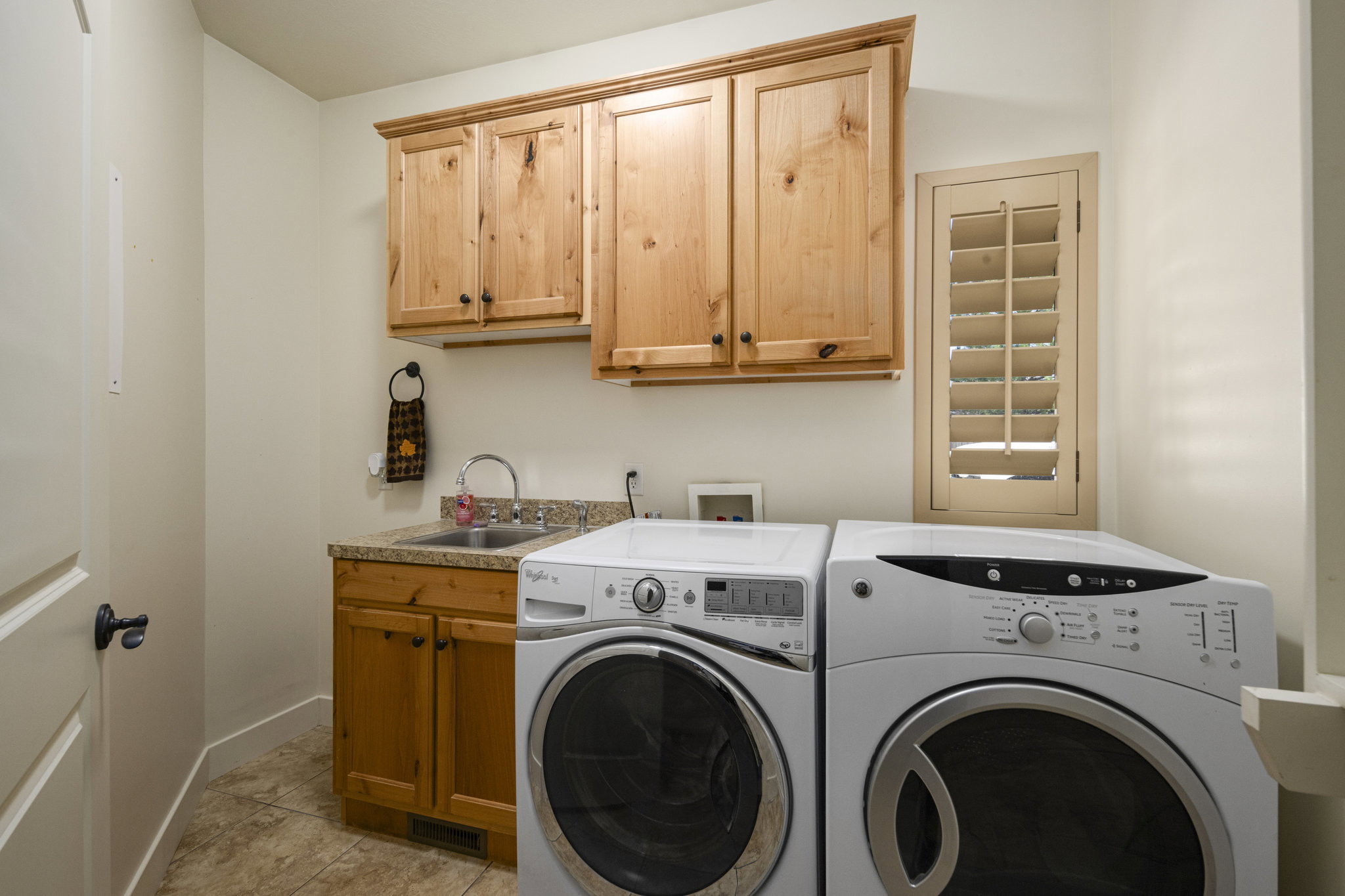 Laundry room featuring cabinet space, washer and dryer, and light tile patterned flooring