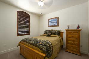 Carpeted bedroom featuring baseboards and ceiling fan