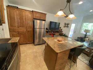 Kitchen with wood finish cabinets, a kitchen bar, stainless steel appliances, and light stone counters