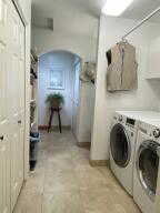 Laundry area featuring arched walkways and washer and dryer