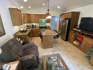 Kitchen featuring wood finish cabinetry, stainless steel appliances, light countertops, and vaulted ceiling