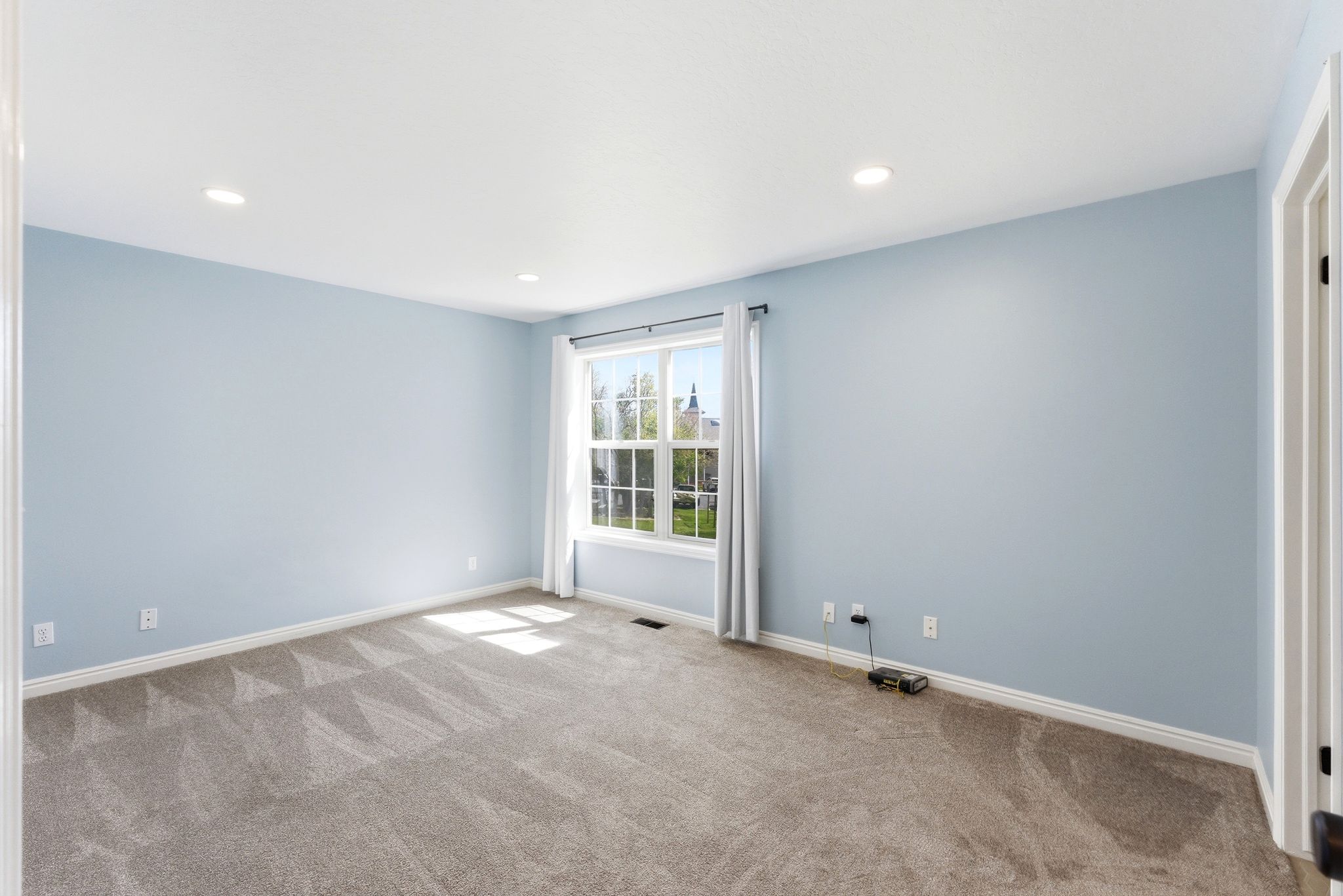 Primary bedroom in Midway condo for sale with large window, soft color palette, and spacious layout