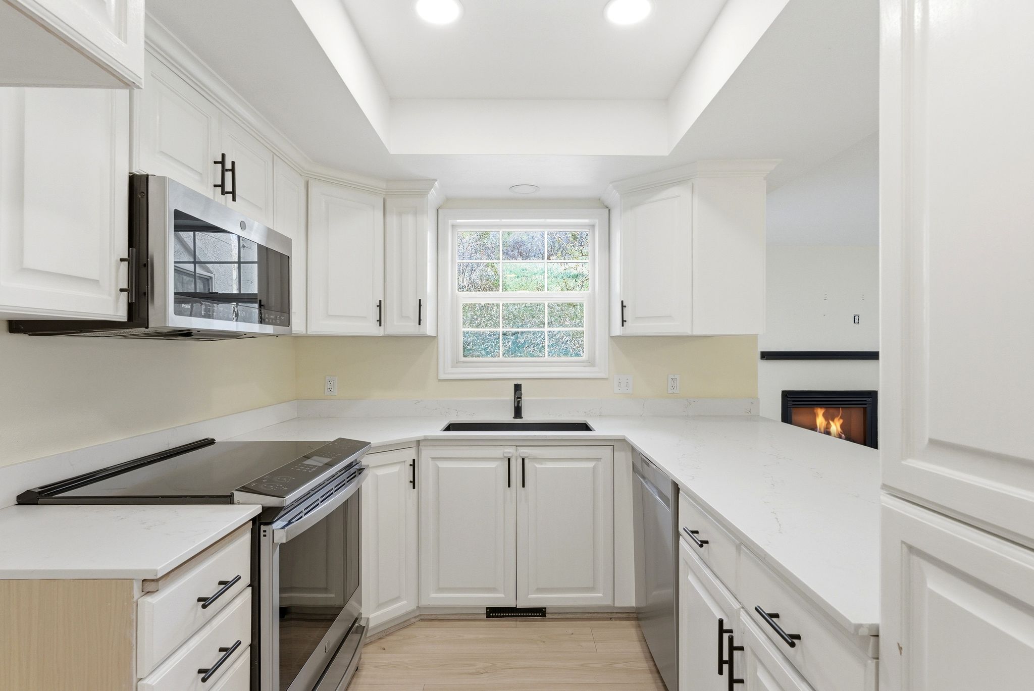 Modern kitchen in Midway condo for sale with quartz countertops, shaker cabinets, stainless steel appliances, and large counter space