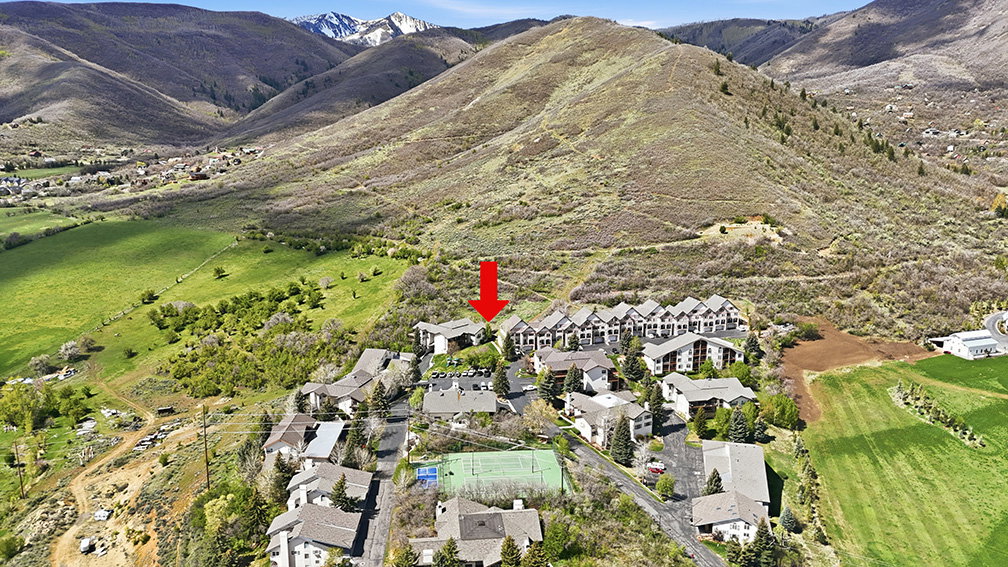 Midway condo for sale aerial with trail system, green space, and mountain views in background. Highlights the connection between the community and nearby trails.