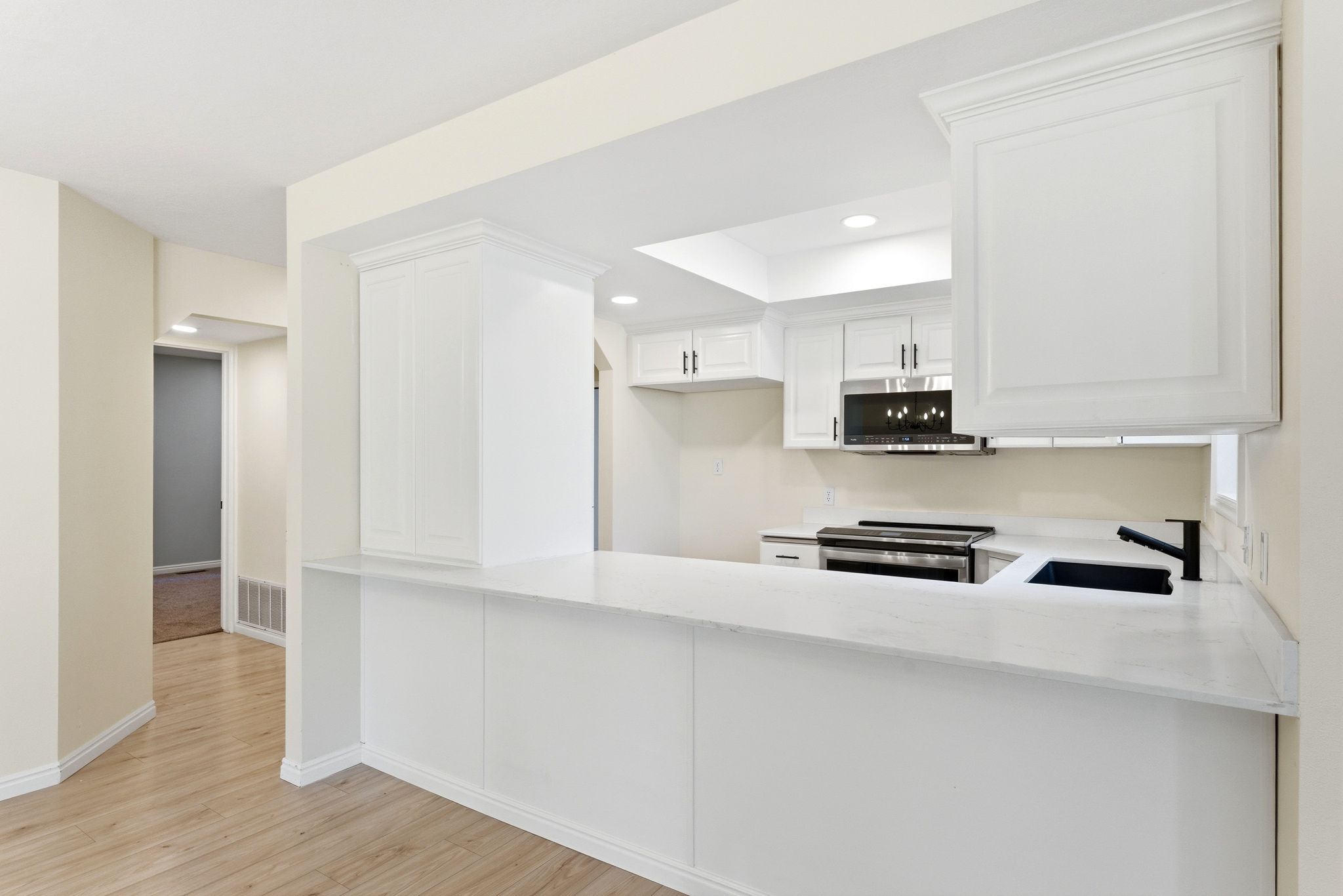 A clean, functional kitchen layout with generous prep space and seating that naturally connects to the main living area