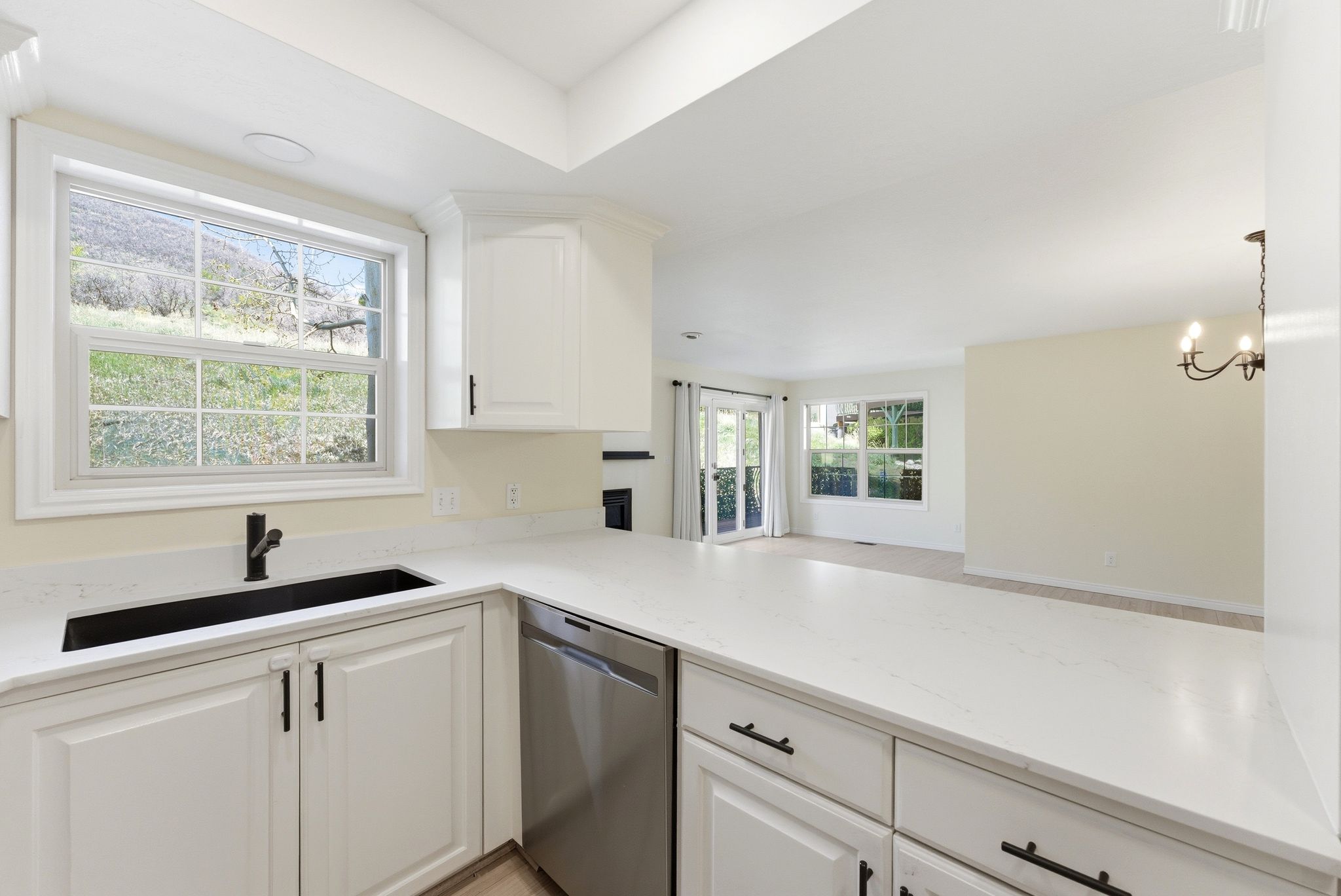 Swiss Oaks condo kitchen with counter seating, modern cabinetry, and direct sightlines to living and dining areas