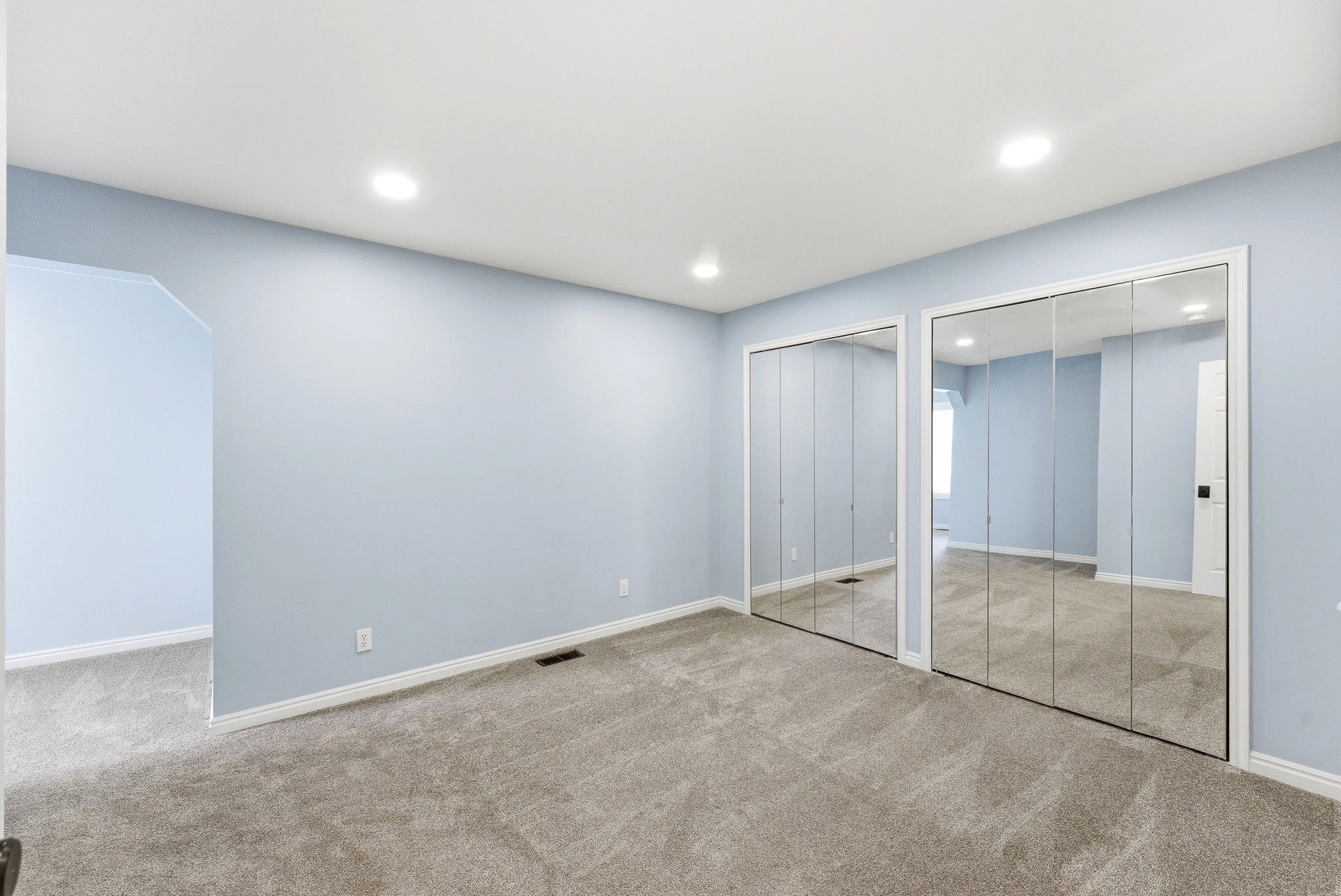 Bedroom in Midway condo for sale with mirrored closet doors, carpet flooring, and attached flex space
