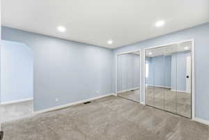 Bedroom in Midway condo for sale with mirrored closet doors, carpet flooring, and attached flex space