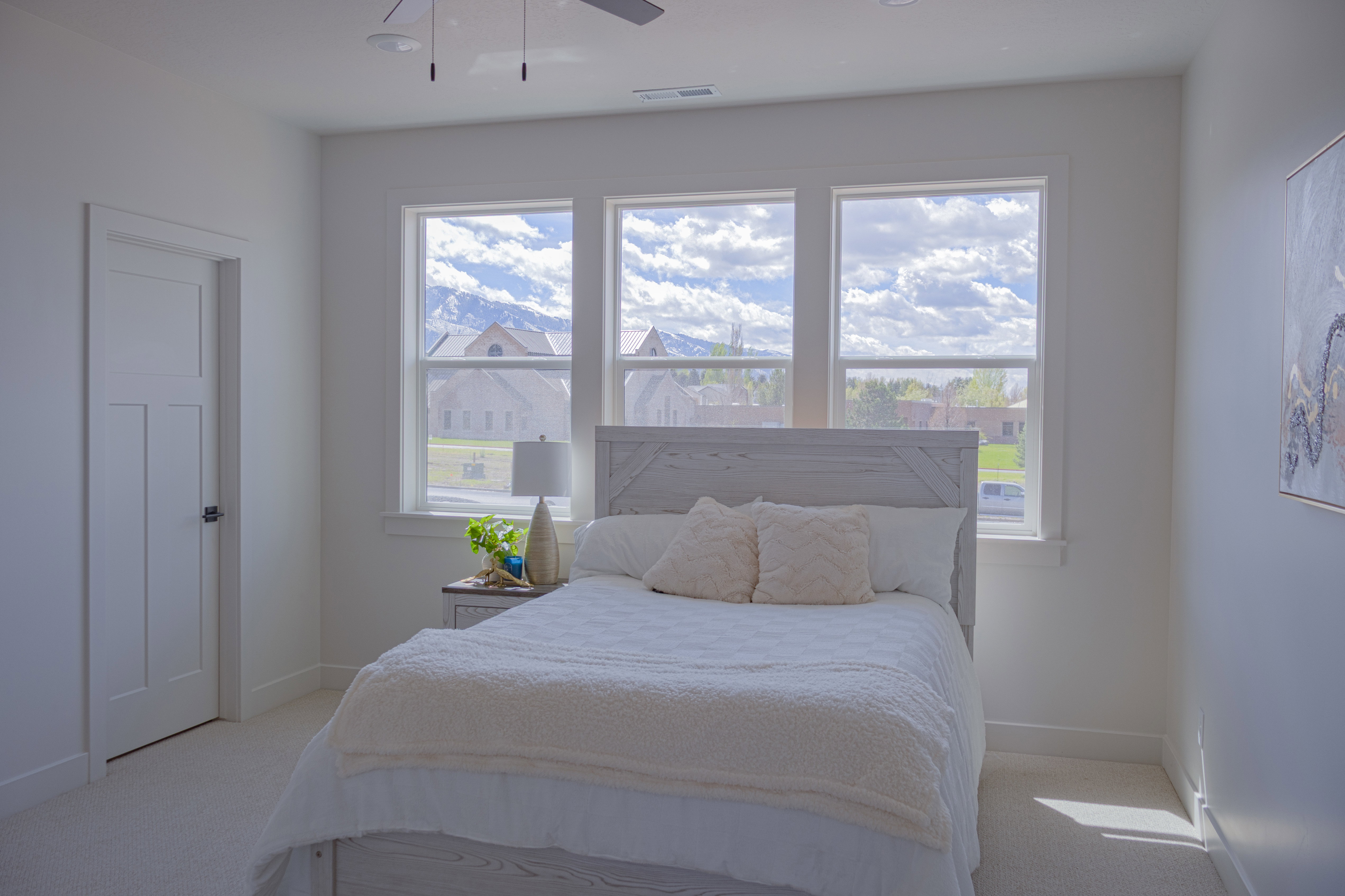 Bedroom with light colored carpet and ceiling fan