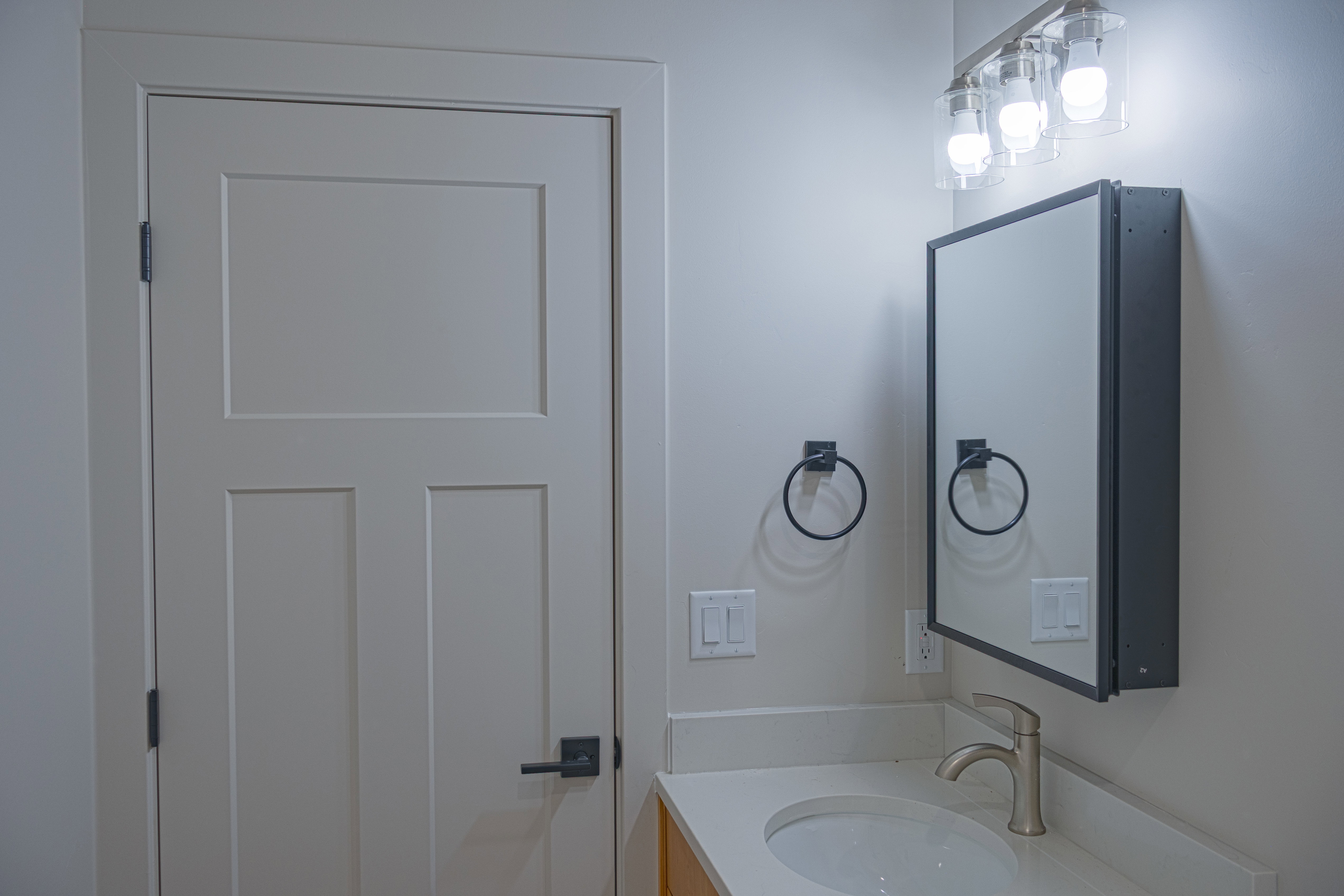 Bathroom featuring vanity and shelved mirror