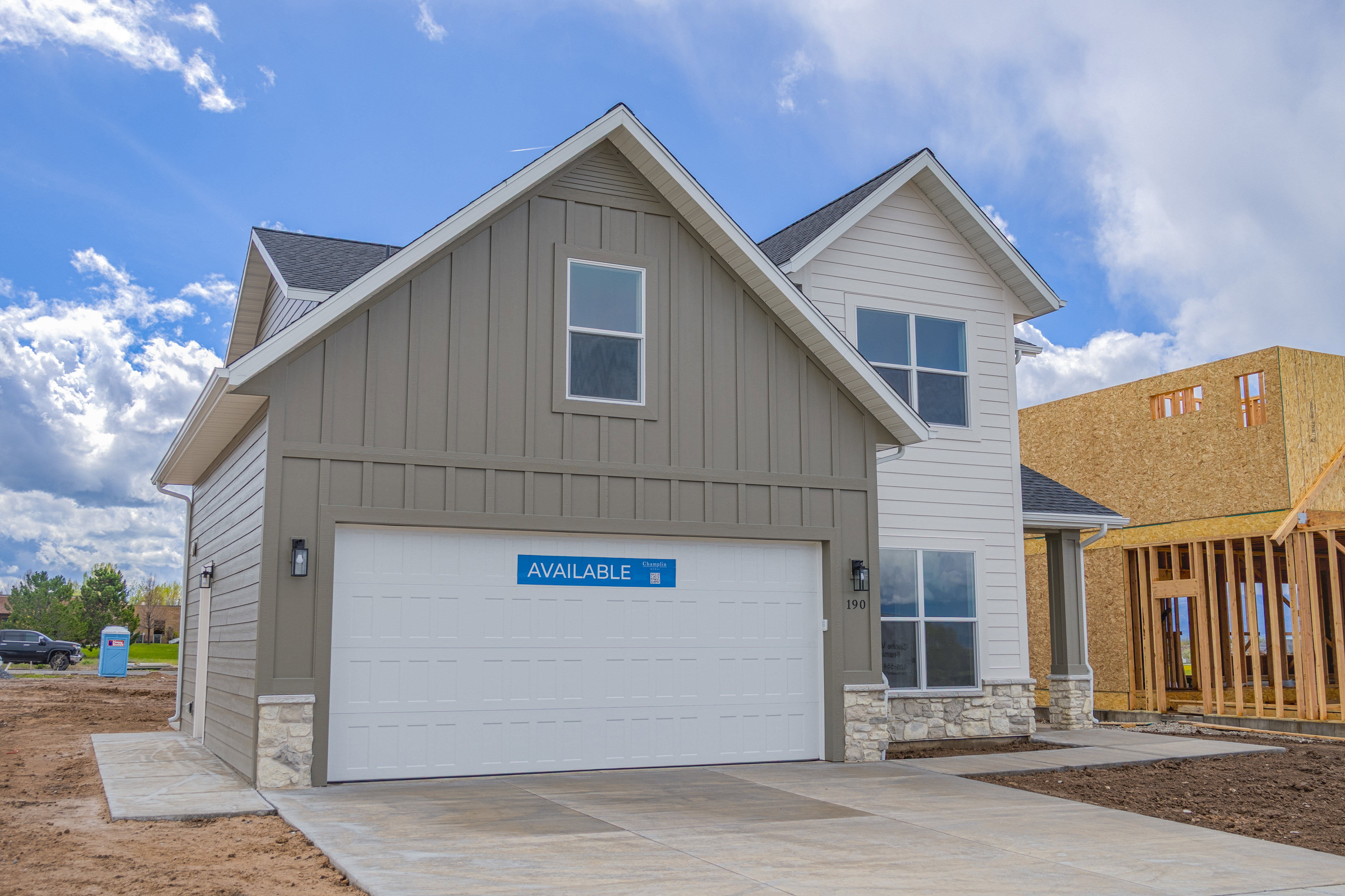 Craftsman house with stone, board and batten siding, and driveway