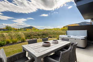 View of patio / terrace featuring a mountain view, outdoor dining space, and a hot tub