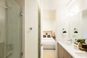 Full bathroom featuring connected bathroom, double vanity, and shower / tub combination