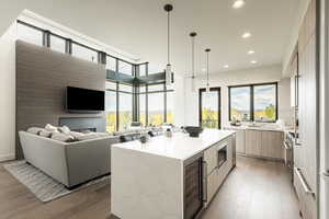 Kitchen with modern cabinets, a kitchen island, open floor plan, light stone counters, and beverage cooler