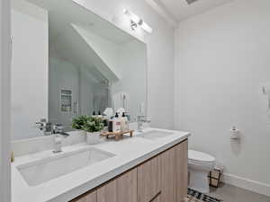 Bathroom with double vanity, light tile patterned floors, and a shower with door