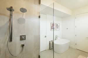 Bathroom featuring a freestanding tub and a tile shower