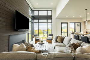 Living area with a large fireplace, recessed lighting, and a high ceiling
