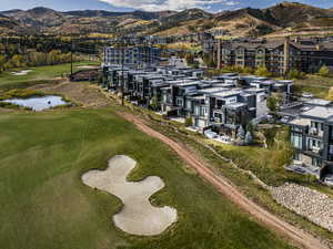 Drone / aerial view of a golf course and a water and mountain view