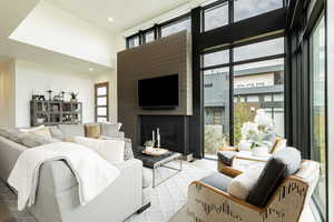 Living area featuring a high ceiling, a fireplace, and recessed lighting