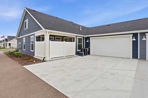 View of front of property featuring roof with shingles, concrete driveway, and a garage