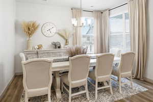 Dining area with wood finished floors and a chandelier
